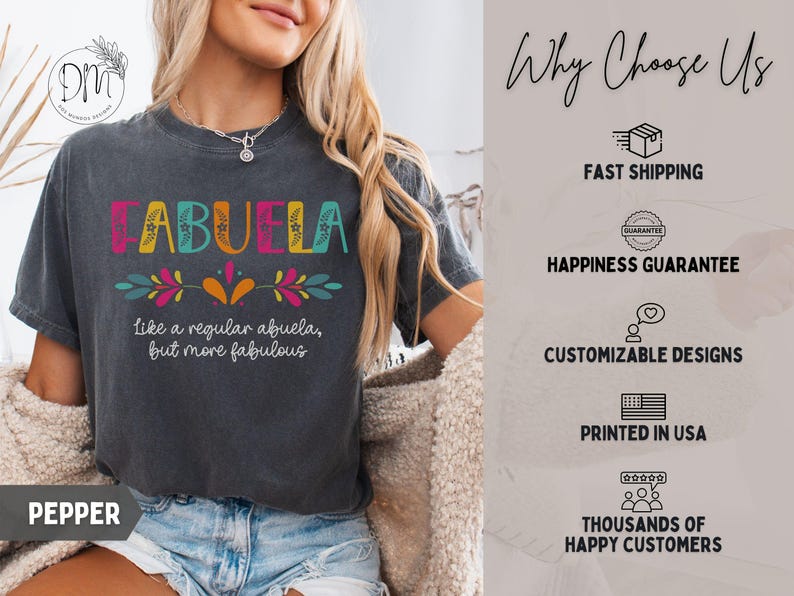 May include: Dark gray t-shirt with the word "ABUELA" in colorful letters. Below the word, it says "Like a regular abuela, but more fabulous." The shirt has a floral design and is printed in the USA.