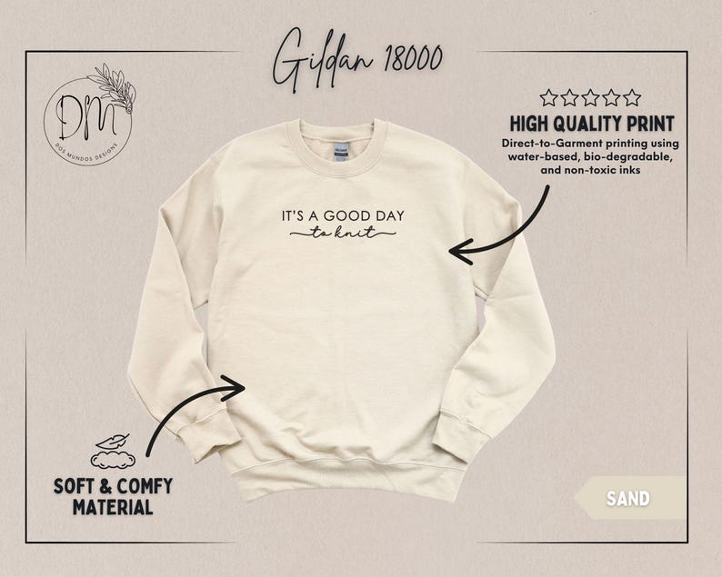 May include: Sand-colored Gildan 18000 sweatshirt with the phrase "IT'S A GOOD DAY to knit" in black script. The image highlights the soft and comfy material and high-quality print using water-based, bio-degradable, and non-toxic inks.
