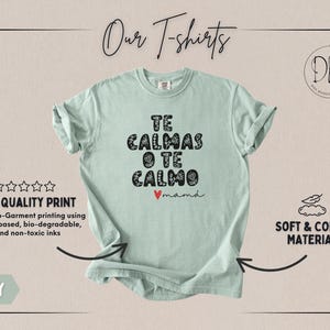 May include: A light green t-shirt with the text "TE CALMAS O TE CALMO mam&aacute;" in black, floral-style lettering. The shirt features a small red heart and is labeled "Our T-shirts". The shirt is made of soft, comfy material.