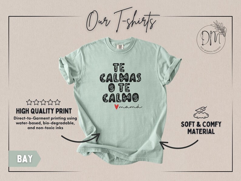 May include: A light green t-shirt with the text "TE CALMAS O TE CALMO mam&aacute;" in black, floral-style lettering. The shirt features a small red heart and is labeled "Our T-shirts". The shirt is made of soft, comfy material.