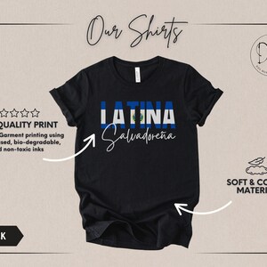 May include: A black short-sleeve t-shirt featuring the word LATINA in block letters filled with the blue and white El Salvador flag pattern, with the word Salvadore&ntilde;a written in white cursive script underneath the flag text.