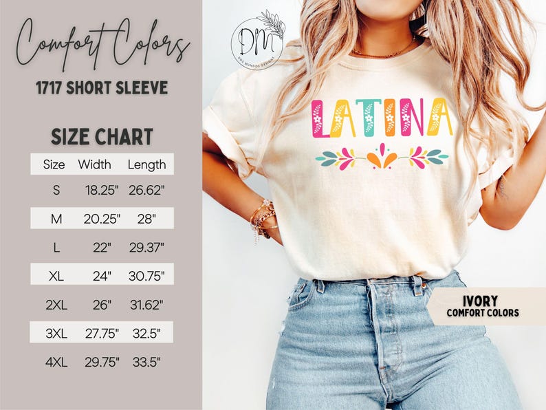 Puede incluir: Camiseta de manga corta de color marfil con la palabra "LATINA" en letras de bloque coloridas. La camiseta presenta un dise&ntilde;o floral debajo de la palabra. Se puede ver una tabla de tallas, con medidas en pulgadas para las tallas S a 4XL. La camiseta es de la marca Comfort Colors.