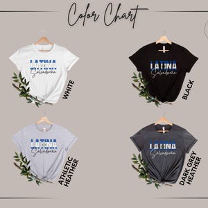 May include: A color chart featuring four short-sleeve t-shirts in white, black, athletic heather, and dark grey heather. Each shirt displays the text LATINA in block letters over a blue and white stripe, with the word Salvadore&ntilde;a below it.