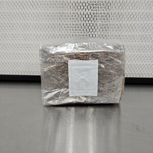 K&ouml;nnte beinhalten: Ein transparenter Plastikbeutel gef&uuml;llt mit braunen K&ouml;rnern, versiegelt mit einem wei&szlig;en Etikett.