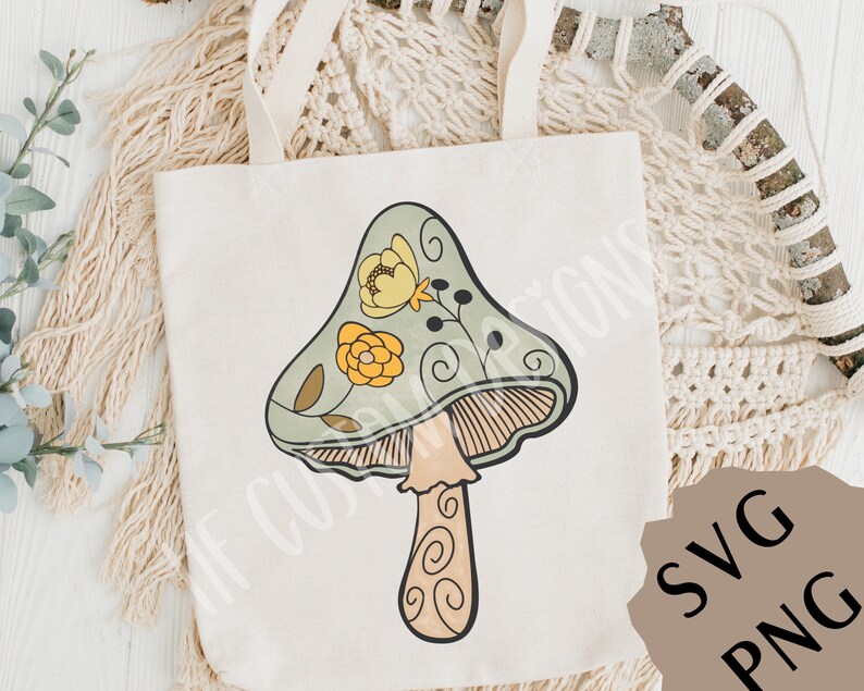 May include: A green and yellow mushroom with floral details on a white tote bag. The mushroom has a brown stem with a swirl pattern. The tote bag has a brown handle.