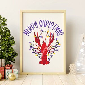 May include: A white framed print with the text "Merry Christmas" in purple lettering. A red crawfish is decorated with purple and yellow Christmas lights.