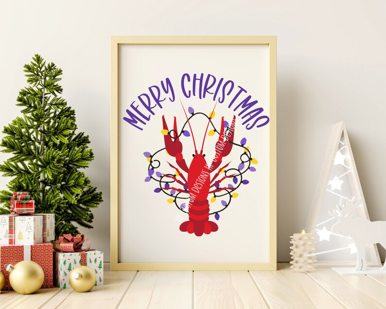 May include: A white framed print with the text "Merry Christmas" in purple lettering. A red crawfish is decorated with purple and yellow Christmas lights.