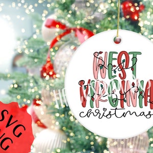 May include: White ceramic Christmas ornament with the text "West Virginia Christmas" in red, pink, and green lettering with a string of lights around the words.