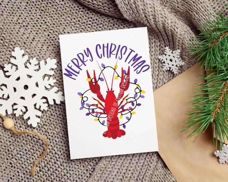 May include: A white card with the text "Merry Christmas" in purple lettering. A red crawfish with purple and yellow lights is illustrated on the card.