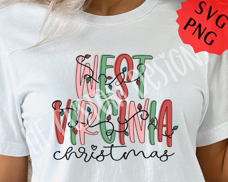 May include: White t-shirt with a festive design that says "West Virginia Christmas" in colorful letters with red and green lights.