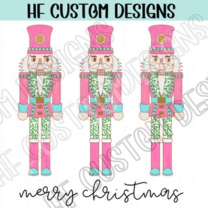 May include: Three pink and white nutcracker figurines with green and gold accents. The nutcrackers are wearing pink hats with gold trim and have white beards. The text "merry christmas" is written below the nutcrackers.