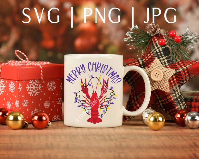 May include: White ceramic mug with a red crawfish and purple Christmas lights, the text "Merry Christmas" is written in purple on the mug.