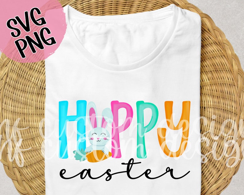 May include: White t-shirt with the text "Happy Easter" in colorful letters. A cartoon bunny holding a carrot is in the middle of the text.