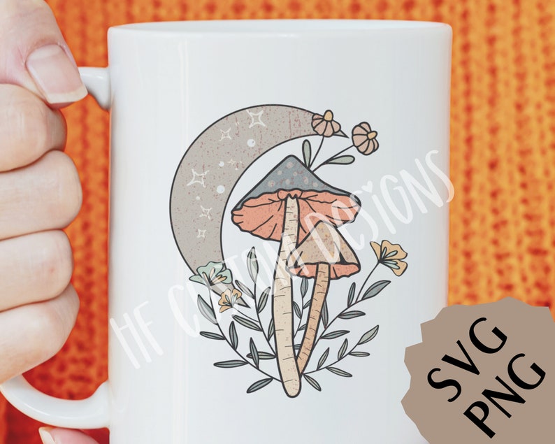 May include: White ceramic mug with a whimsical illustration of two mushrooms with orange and gray caps, growing from green foliage under a crescent moon with stars. The design is in a vintage style.