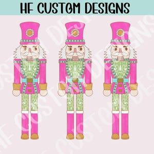 Puede incluir: Tres figuras de cascanueces de color rosa y blanco con detalles en verde y azul. Los cascanueces están de pie con los brazos a los lados. Los cascanueces tienen un diseño caprichoso y festivo.