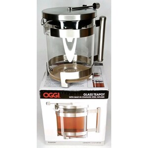 May include: A clear glass teapot with a stainless steel infuser and lid. The teapot has a handle and sits on a box that reads "Glass Teapot with Built-in Stainless Steel Infuser". The teapot has a capacity of 40 oz.