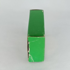 K&ouml;nnte beinhalten: Eine gr&uuml;ne Pappbox mit leicht abgenutzter Oberfl&auml;che.
