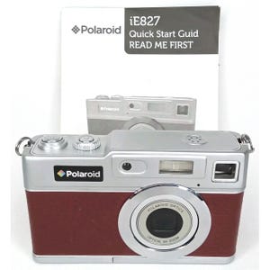 May include: A silver and burgundy Polaroid iE827 digital camera with a prominent lens and flash. The camera has the Polaroid logo and the words "Polaroid Optics Optical 8X Zoom" on the lens. A quick start guide is in the background.