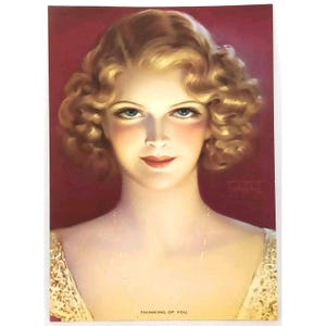 May include: A vintage postcard featuring a woman with blonde, curly hair. She is wearing a white lace dress and has a pearl necklace. The background is a deep red color. The text "Thinking of You" is printed at the bottom of the postcard.