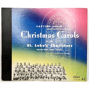 May include: A vintage vinyl record album cover titled Capitol presents Christmas Carols by the St. Luke's Choristers, William Ripley Dorr, Conducting. The cover features a black spine, a gradient background, and a black and white choir photo.