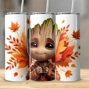 Könnte beinhalten: Drei weiße Edelstahlbecher mit einem Cartoon-Charakter, umgeben von Herbstblättern. Der Charakter hat ein holzartiges Aussehen, große braune Augen und eine braune Jacke. Die Blätter sind in Orange- und Rottönen gehalten.