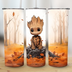 Könnte beinhalten: Drei Edelstahlbecher mit Herbst-Motiv. Der mittlere Becher zeigt ein Cartoon-Bild eines braunen und grünen Groot-Charakters, der auf einem Baumstumpf sitzt. Der Hintergrund aller drei Becher ist eine Waldszene mit braunen Bäumen und orangefarbenen Blättern.