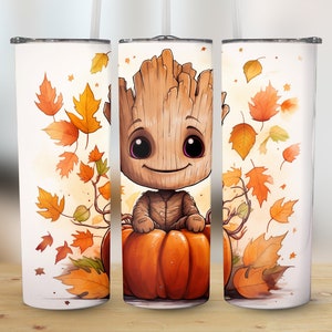 Könnte beinhalten: Ein weißer Becher mit einer Cartoonfigur, die auf einem orangefarbenen Kürbis sitzt, umgeben von Herbstblättern. Die Figur hat ein hölzernes Aussehen mit großen Augen und einem freundlichen Lächeln. Das Design umfasst Orange-, Gelb- und Brauntöne, mit einem Strohhalm und Deckel.