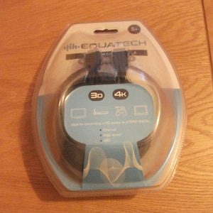 May include: A clear plastic package containing a black HDMI cable. The package is labeled "2m" and "EQUJATECH". The cable is advertised as supporting 3D and 4K resolution.