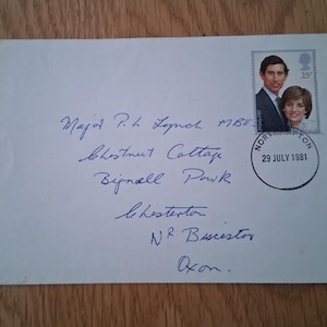 Può includere: Una busta bianca con indirizzo manoscritto e francobollo con il principe Carlo e la principessa Diana. Il francobollo è timbrato il 29 luglio 1981, da Norton. La busta è indirizzata al maggiore P.H. Lynch.