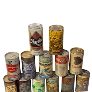 Puede incluir: Una colección de catorce latas de cerveza de metal vintage dispuestas en forma de pirámide. Las latas presentan varios logotipos de marcas coloridos, ilustraciones y texto, incluidos Stroh's, Yuengling, Gibbon y Lionshead, con etiquetas de 355 ml.