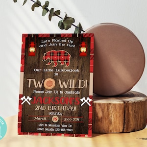 May include: A red and black plaid lumberjack birthday invitation with a cartoon bear, the text "Two Wild!" and the words "Jackson's 2nd Birthday!"  The invitation is set against a woodgrain background with a red and black plaid border.