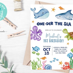 May include: A blue and white invitation for a first birthday party with an under the sea theme. The invitation features a whale, octopus, turtle, and fish. The text reads "One-der the Sea" and "Join us to celebrate Michael's 1st Birthday!"  The date is Saturday, October 18th. The address is 12938 N. Main Rd., Cary, GA 12345. The RSVP number is 123-456-7890.
