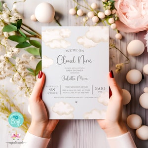Könnte beinhalten: Eine Babyparty-Einladung mit einem Aquarell-Design von Wolken auf hellblauem Hintergrund. Der Text lautet "We're on Cloud Nine" und enthält Datum, Uhrzeit und Ort der Veranstaltung. Die Einladung ist für Julietta Moore.