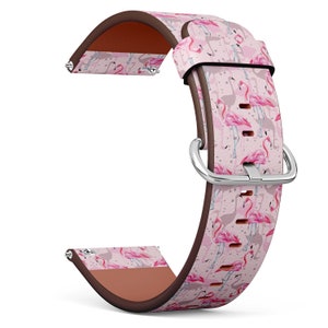 May include: Pink leather watch strap with a flamingo print. The strap has a brown leather lining and a silver buckle.