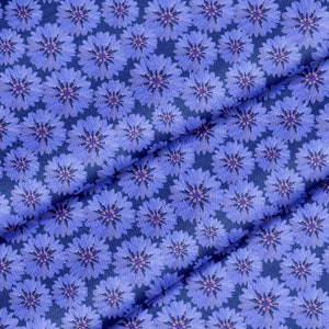 Pode incluir: Um tecido azul com um padrão repetitivo de flores azuis claras com centros rosados.