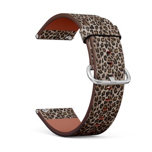 Pode incluir: Uma pulseira de relógio de couro marrom com um design de estampa de leopardo. A pulseira tem uma fivela prateada e é compatível com smartwatches.