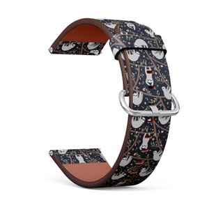 May include: A brown leather watch band with a black and white pattern of sloths hanging from branches. The band has a silver buckle.