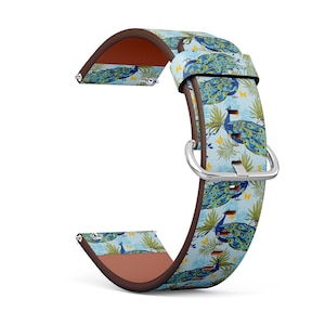 Könnte beinhalten: Ein Uhrenarmband mit einem Pfauenfedermuster. Das Band hat einen hellblauen Hintergrund mit Pfau-Illustrationen in Blau, Grün und Gelb. Es hat eine braune Lederunterseite und eine silberne Schnalle.