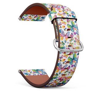 May include: A white leather watch band with a colorful butterfly pattern. The band has a brown leather lining and a silver buckle.