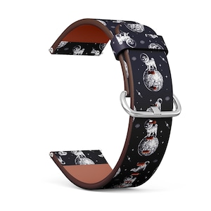 May include: A black leather watch band with a white and gray pattern of pugs wearing astronaut suits and standing on the moon. The band has a silver buckle.