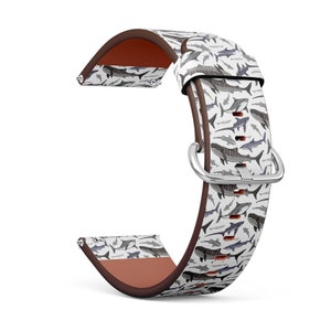 May include: A brown leather watch strap with a white background and a pattern of sharks and other fish. The strap is designed for a smartwatch.