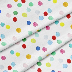 May include: White fabric with a colorful confetti pattern. The fabric is folded in thirds, showing the pattern repeating. The confetti is made of watercolor dots in various colors, including red, blue, green, yellow, and pink.