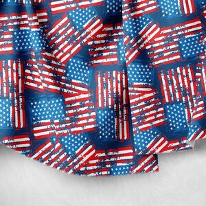 Könnte beinhalten: Ein blauer Stoff mit einem sich wiederholenden Muster aus rot-weiß-blauen amerikanischen Flaggen. Die Flaggen sind abgenutzt und haben einen Vintage-Look.