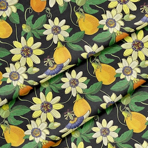 May include: A fabric with a repeating pattern of passion flowers and passion fruits. The flowers are yellow and white with purple centers, and the fruits are yellow. Green leaves and vines are also present on a black background.