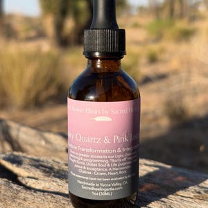 May include: A brown glass bottle with a black dropper and a label that reads "Smoky Quartz & Pink Jasmine." The label also includes text about shadow transformation and integration. The bottle contains 1 oz (30ML) of product.