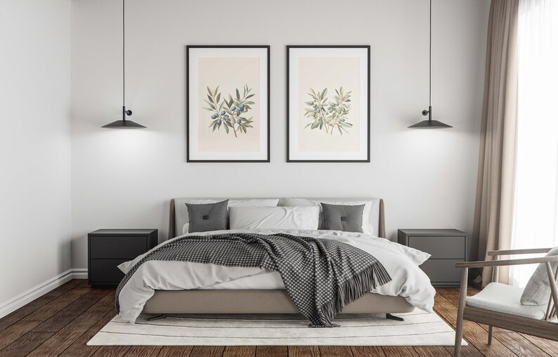 May include: A modern bedroom with a bed, two black nightstands, and two framed botanical prints. The bed has a gray headboard, white bedding, and a gray and white patterned throw blanket. Two black pendant lights hang above the bed.