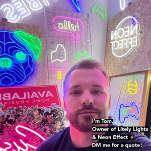 May include: A man with a beard stands in front of a wall with neon signs. The signs say "alled", "HOME BUSINESS", "BAJAVA", "NEON EFFECT", and "LITESLY LIGHTS". The man is wearing a black shirt and has a pink and purple glow on his face. The text on the image says "I'm Tom, Owner of Litely Lights & Neon Effect. DM me for a quote!"