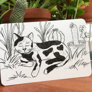 Postal ilustrada a mano de un gato tirado cerca de un cactus | lindo gato durmiendo en las plantas | regalo para amante de los gatos