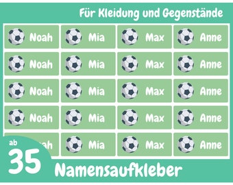 May include: A sheet of green name labels featuring soccer ball designs. Each label displays a name: Noah, Mia, Max, and Anne. The text "Für Kleidung und Gegenstände" and "Namensaufkleber" are present, with the number "35" in the corner.