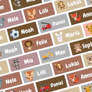 Puede incluir: Etiquetas rectangulares con nombres e ilustraciones de animales. Las etiquetas son en tonos marrones, grises y rosas. Los animales incluyen un zorro, un mono y un león. Nombres: Noah, Mia y Daniel.